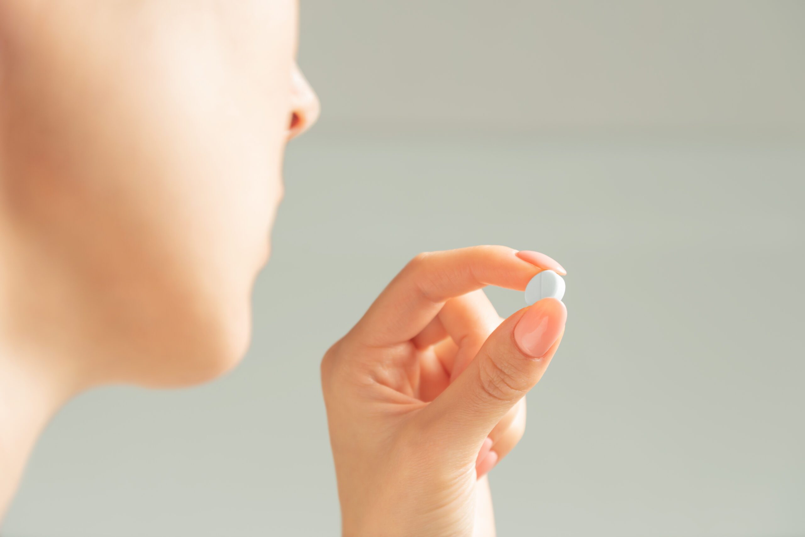 Woman holding a medical pill or vitamin. Woman considering taking the abortion pill